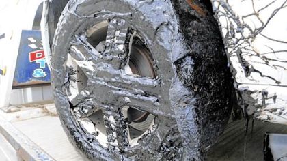 A vehicle's tire is shown covered in a tar-like chemical Wednesday near Oakmont.