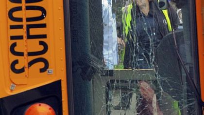 A school bus that carried Trinity High School band students rests on its side after flipping over on South Main Street in Amwell, Washington County, on Friday.