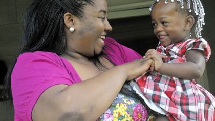 Brittney Morton, 24, left, plays with her 1-year-old daughter, Maliyiah Meadows, on the porch of their Homewood home. Ms. Morton has the heart ailment peripartum cardiomyopathy, which attacks women during pregnancy or in the first five months after childbirth.