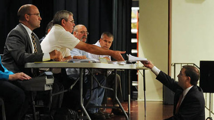 South Fayette Township solicitor Jonathan M. Kamin, center, hands a motion to John Alan Kosky of the township Zoning Board during an Oct. 12 hearing at South Fayette Township Middle School.