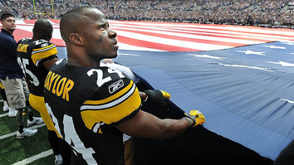 Steelers' Ike Taylor helps to hold the flag during the National Anthem before the game.