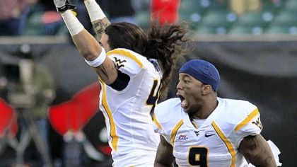 West Virginia's Vernard Roberts, right, and Matt Moro celebrate their dramatic victory Saturday in Cincinnati. Eain Smith blocked a field-goal attempt that would have tied the score.