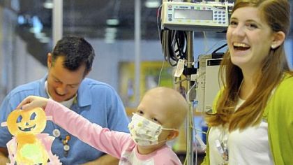 Cancer patient Cadence Charmello, 6, of Kittanning shows her Halloween cutout at Children's Hospital of Pittsburgh of UPMC. With her are child life specialists Michael Shulock and Katie Fole. Mr. Shulock is on the board of Lending Hearts.