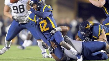 Pitt's Myles Caragein forces West Virginia quarterback Geno Smith to toss the ball away in the first quarter last night at Mountaineer Field in Morgantown, W.Va.