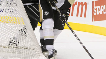 Evgeni Malkin takes the puck around the net as he is defended by Los Angeles Kings defenseman Willie Mitchell.