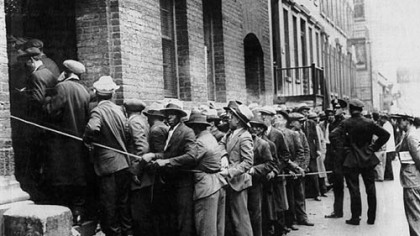 Men wait outside an unemployment relief registration center in New York City during the Great Depression.