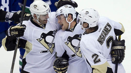 Penguins left wing Matt Cooke, center, celebrates his first-period goal with teammates Pascal Dupuis (9) and Matt Niskanen (2) during season opener against Vancouver.