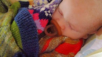 Cosette Cornelius-Bates' son, Malachi, at 4 months, napping in a sweater and with a blanket made with some of her hand-dyed, hand-spun skeins.