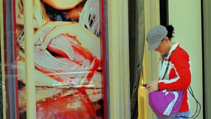 Christie Concepcion of Seven Fields in Butler County sets her shopping bags down in front of the Victoria's Secret at The Mall at Robinson to check her phone messages Friday.