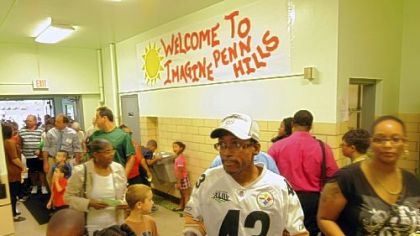 Parents and children walk into the new charter school in Penn Hills during the open house and tour.