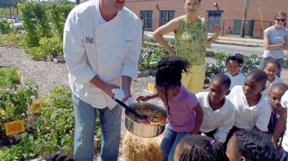 Big Burrito executive chef Bill Fuller shows his cooking to first graders of Helen Faison Arts Academy at their school garden in Homewood 2007.
